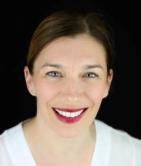 A person smiling at the camera
Description automatically generated